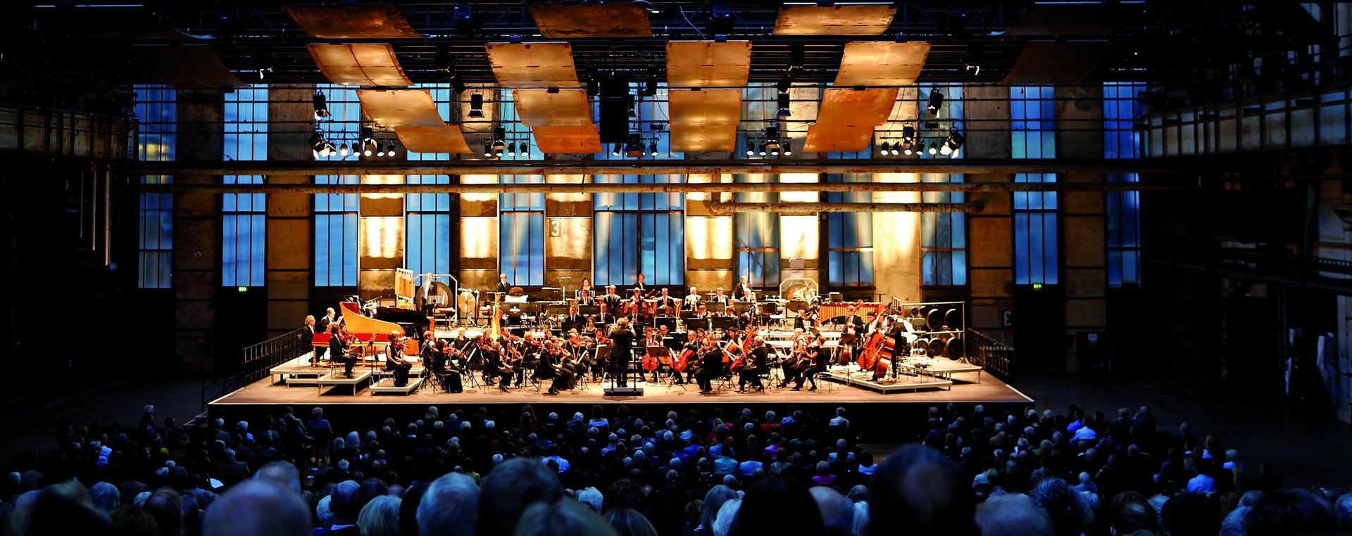 Orchester auf einer Bühne davor Publikum