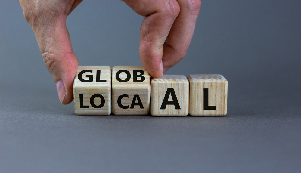 4 bedruckte Würfel nebeneinander, Schriftzug Think global Act local